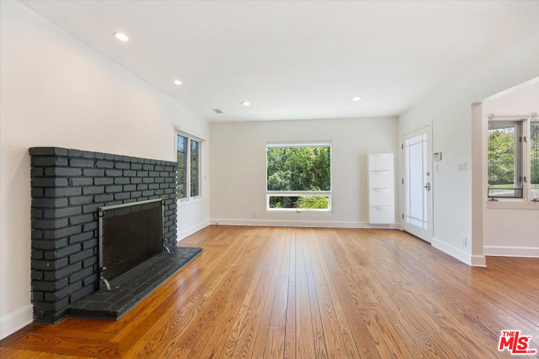 14041 Roblar Road Sherman Oaks, CA 91423 - Photo 7 of 47 an empty room with windows and fireplace
