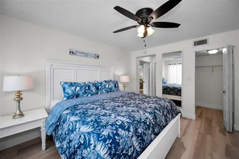 a bedroom with a large bed and a chandelier