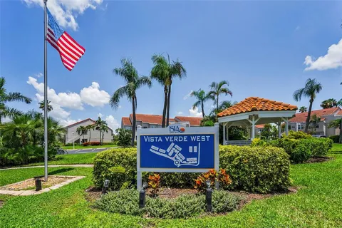 a view of a house with a yard and a bench