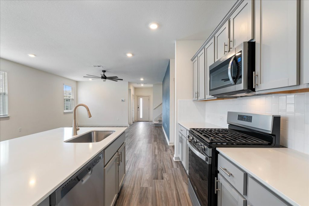 7410 Sagira Path Austin, TX 78724 - Photo 12 of 37 a kitchen with stainless steel appliances granite countertop a sink stove and microwave