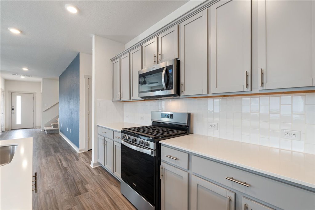7410 Sagira Path Austin, TX 78724 - Photo 10 of 37 a kitchen with granite countertop a sink a stove and cabinets
