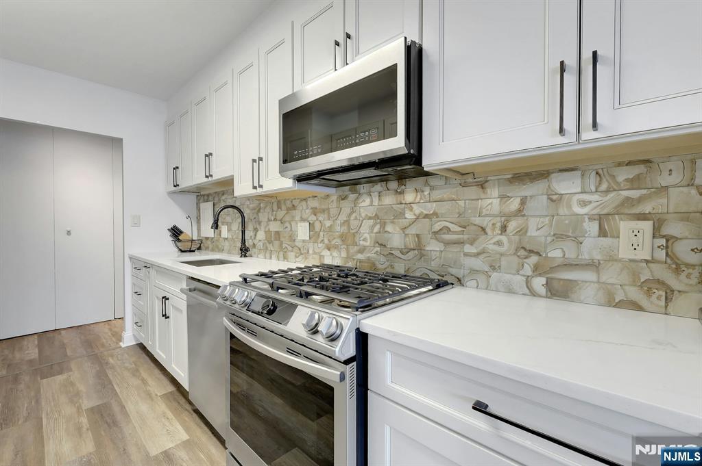 6 Horizon Road, Unit 2209 Fort Lee, NJ 07024 - Photo 11 of 50 a kitchen with stainless steel appliances a stove a microwave oven cabinets and a sink