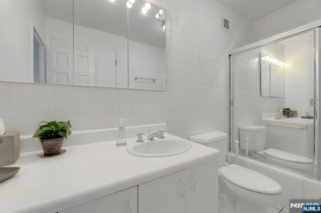 6 Horizon Road, Unit 2209 Fort Lee, NJ 07024 - Photo 38 of 50 a bathroom with a sink a toilet and mirror