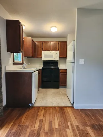 a kitchen with granite countertop a stove cabinets and a refrigerator