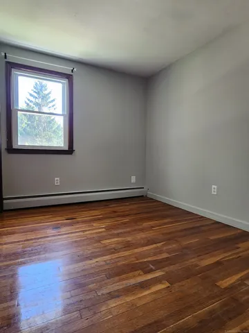 a view of a room with wooden floor and window