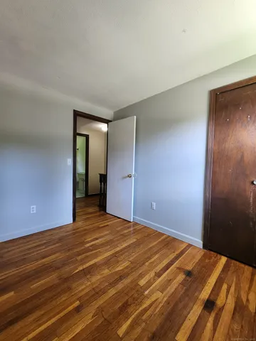 a view of an empty room with closet and a window