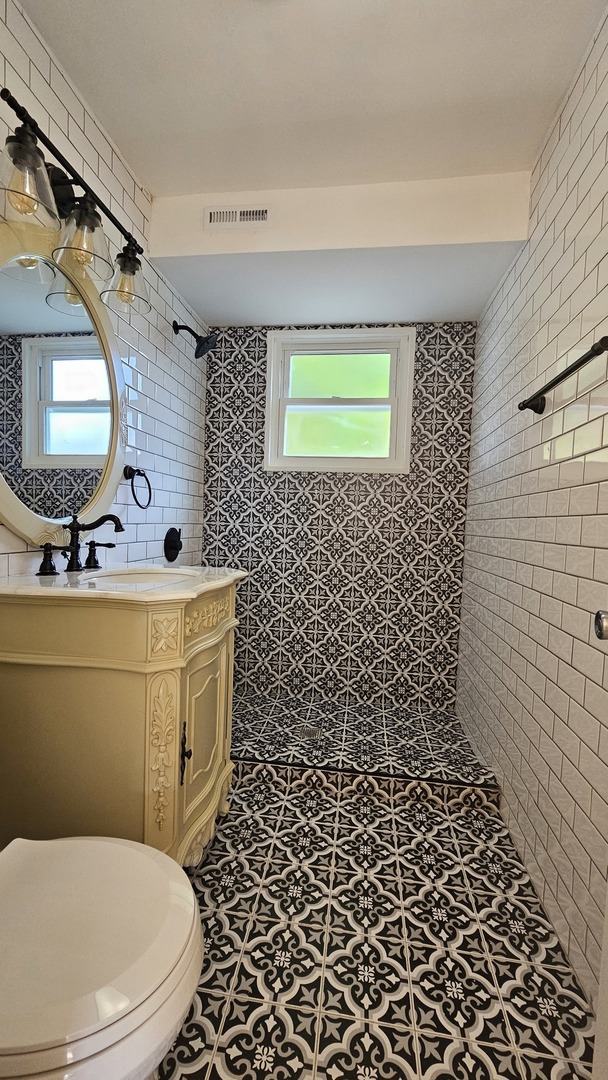 7233 West 85th Street Bridgeview, IL 60455 - Photo 7 of 15 a bathroom with a toilet sink and mirror