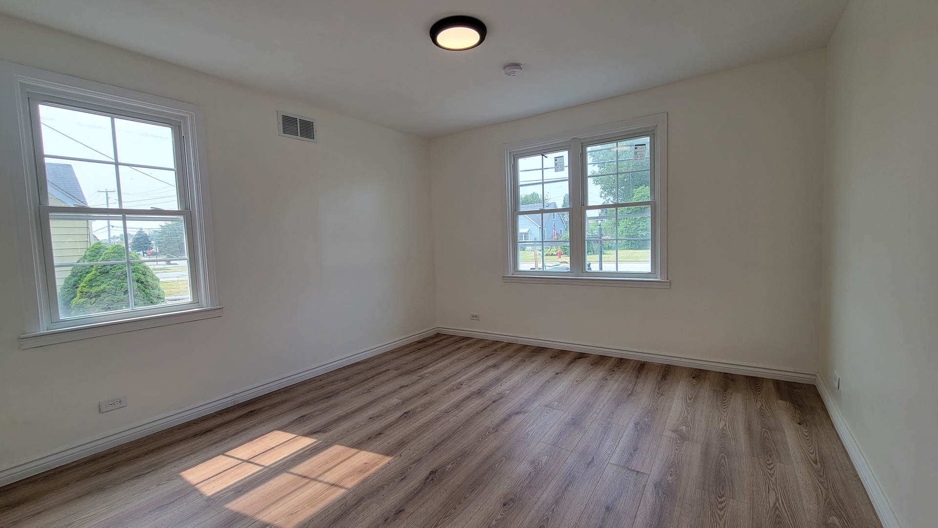 7233 West 85th Street Bridgeview, IL 60455 - Photo 9 of 15 a view of an empty room with wooden floor and a window