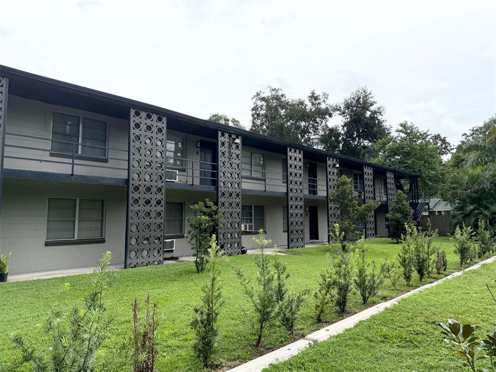 639 Ramona Lane, Unit 8 Orlando, FL 32805 - Photo 1 of 11 a view of a house with brick walls and a yard with plants