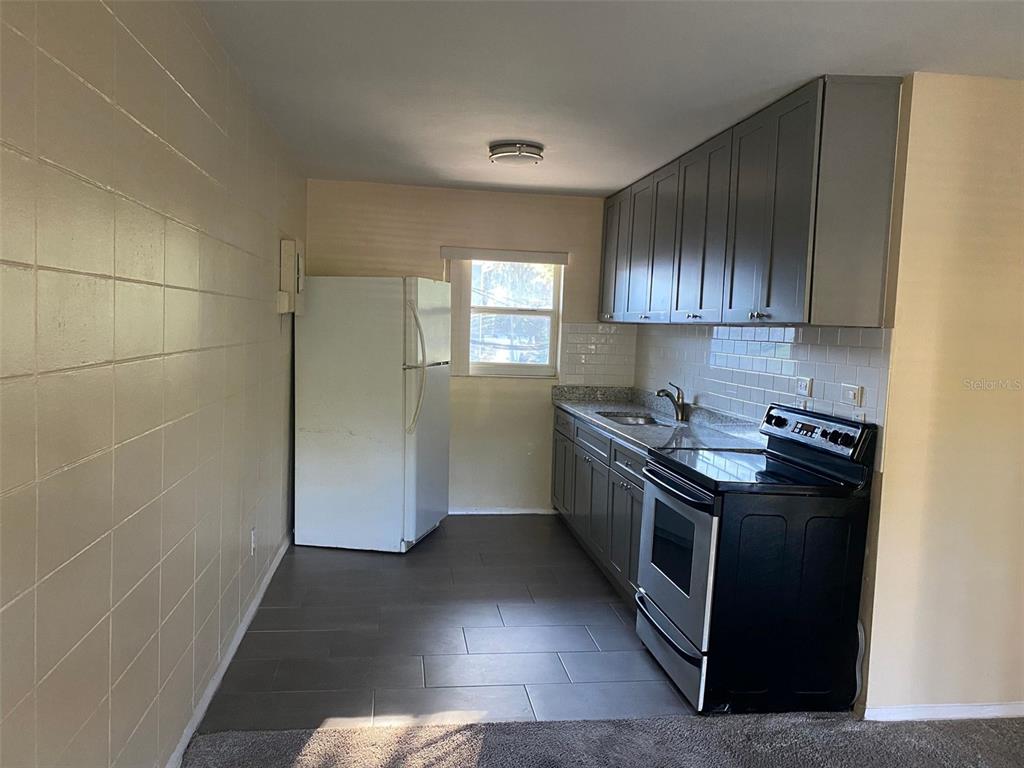 639 Ramona Lane, Unit 8 Orlando, FL 32805 - Photo 3 of 11 a kitchen with a stove a sink and a refrigerator