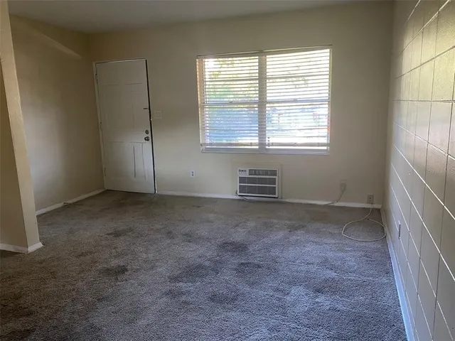 an empty room with a window and a fan