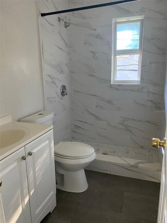 639 Ramona Lane, Unit 8 Orlando, FL 32805 - Photo 8 of 11 a bathroom with a toilet a sink and shower