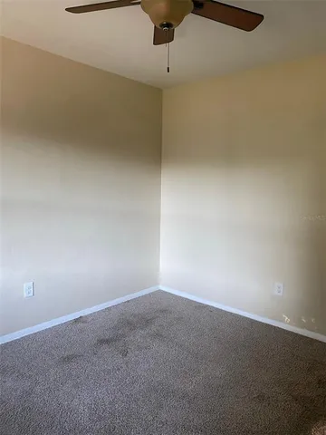 an empty room with a ceiling fan and a window