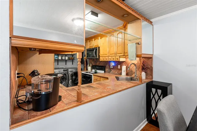 a kitchen with stainless steel appliances granite countertop sink and wooden cabinets