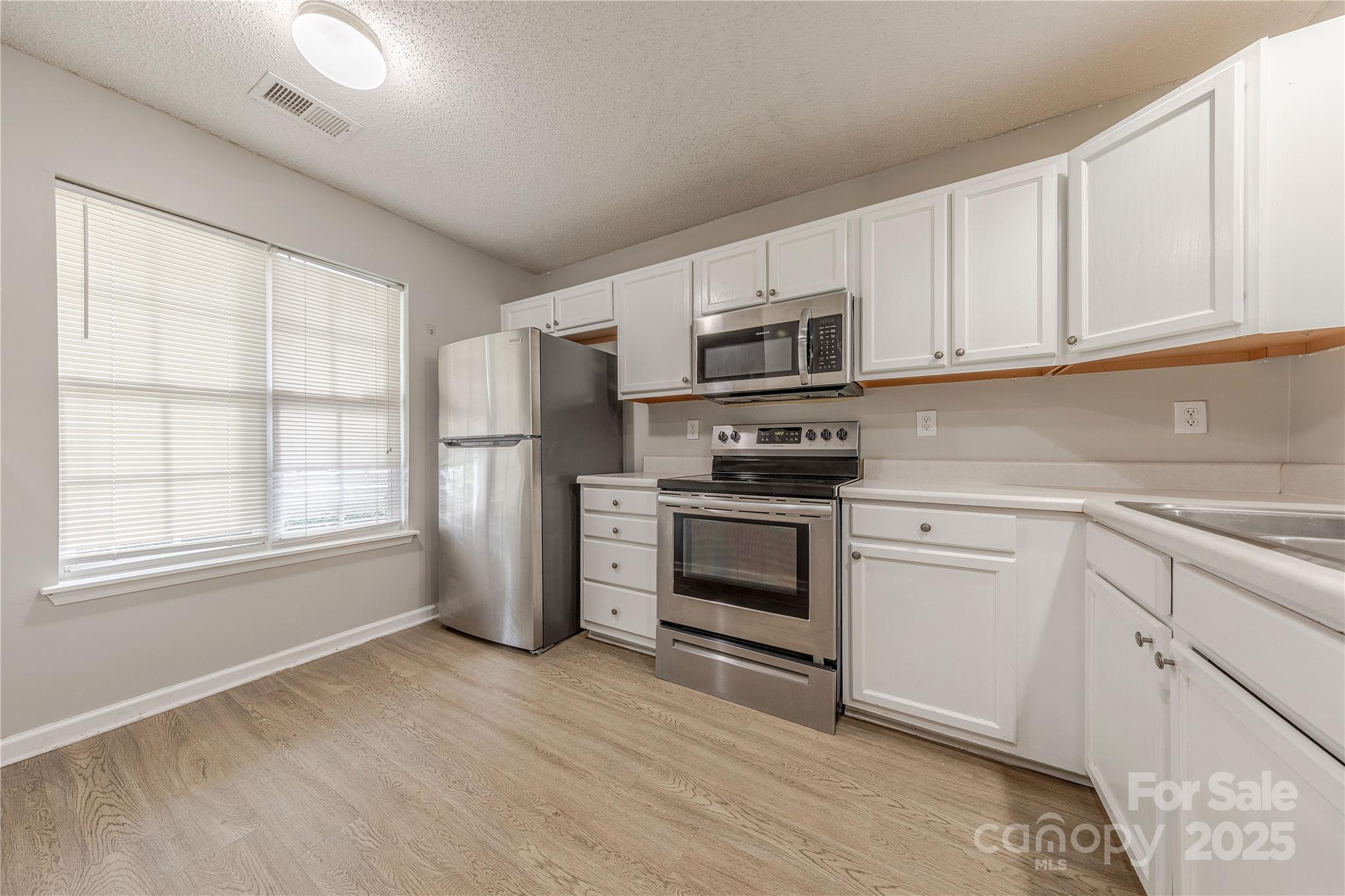 1809 Birch Heights Court Charlotte, NC 28213 - Photo 3 of 23 a kitchen with granite countertop white cabinets and stainless steel appliances