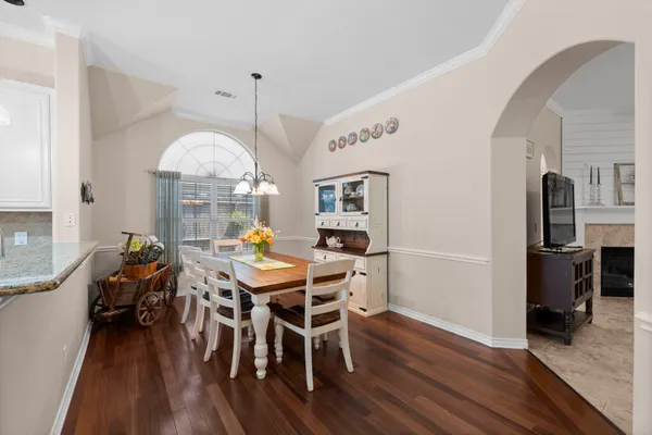 a view of a dining room with furniture a chandelier and wooden floor