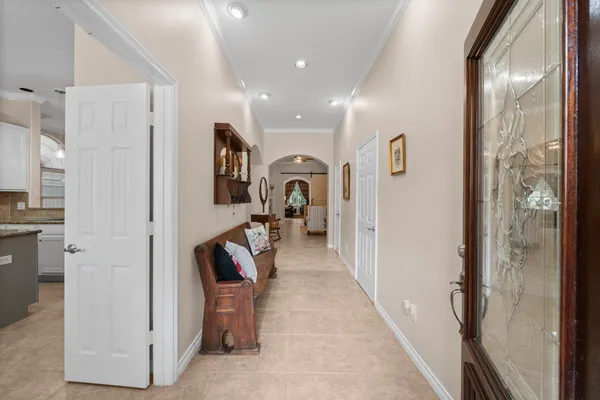 a living room with furniture a rug a wall clock and a potted plant