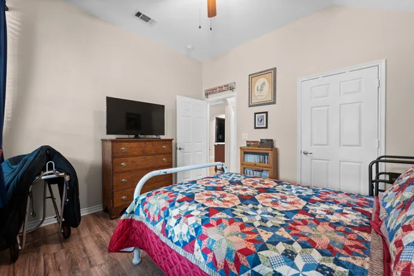 a spacious bedroom with a bed a couch and a chandelier