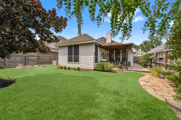 a view of a backyard with a small cabin and wooden fence