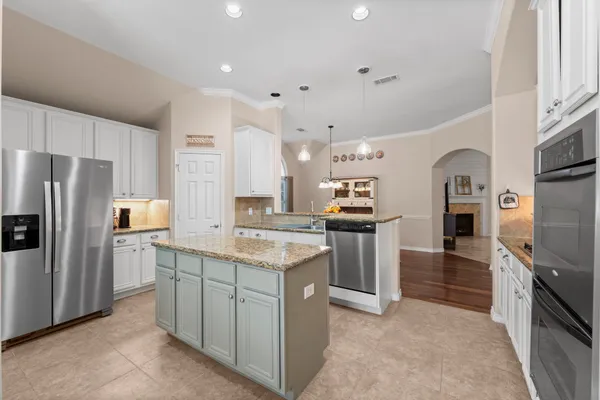 a kitchen with granite countertop a sink stove and refrigerator