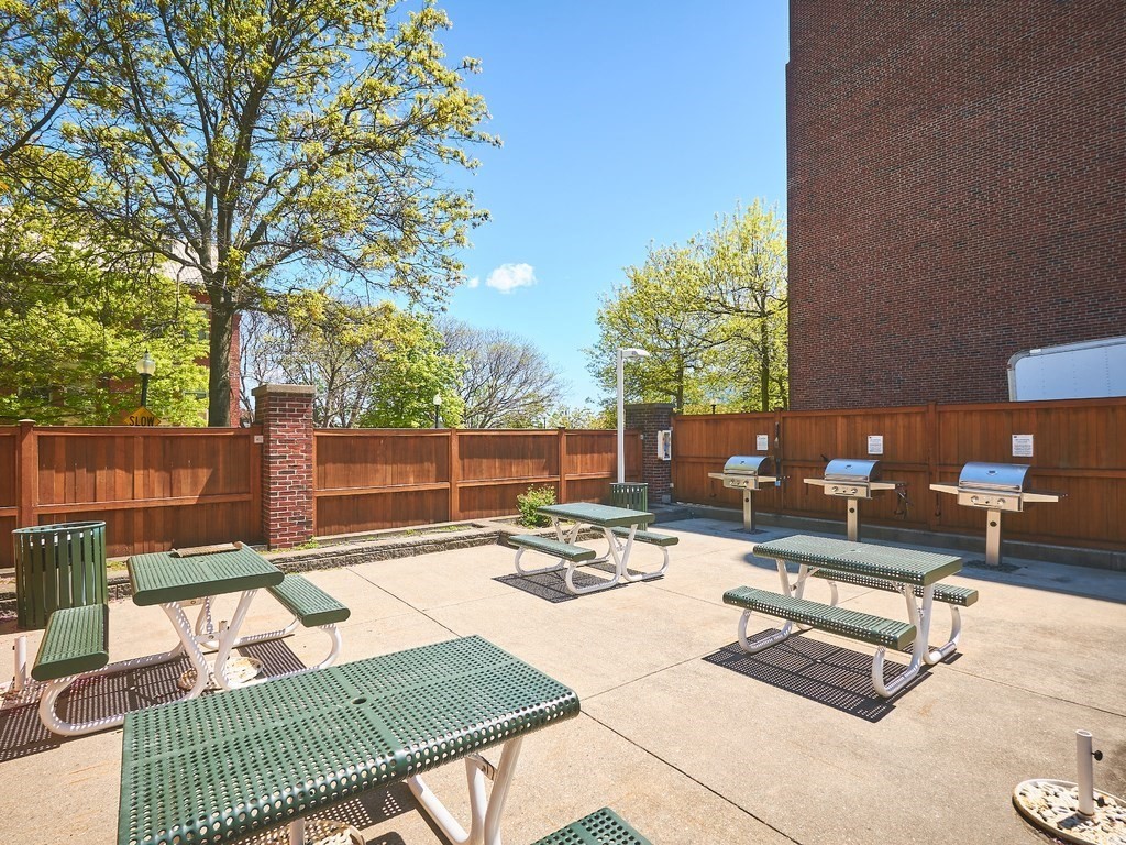 42 8th Street, Unit 5521 Boston, MA 02129 - Photo 16 of 25 a view of a patio with couches and a table and chairs with wooden fence