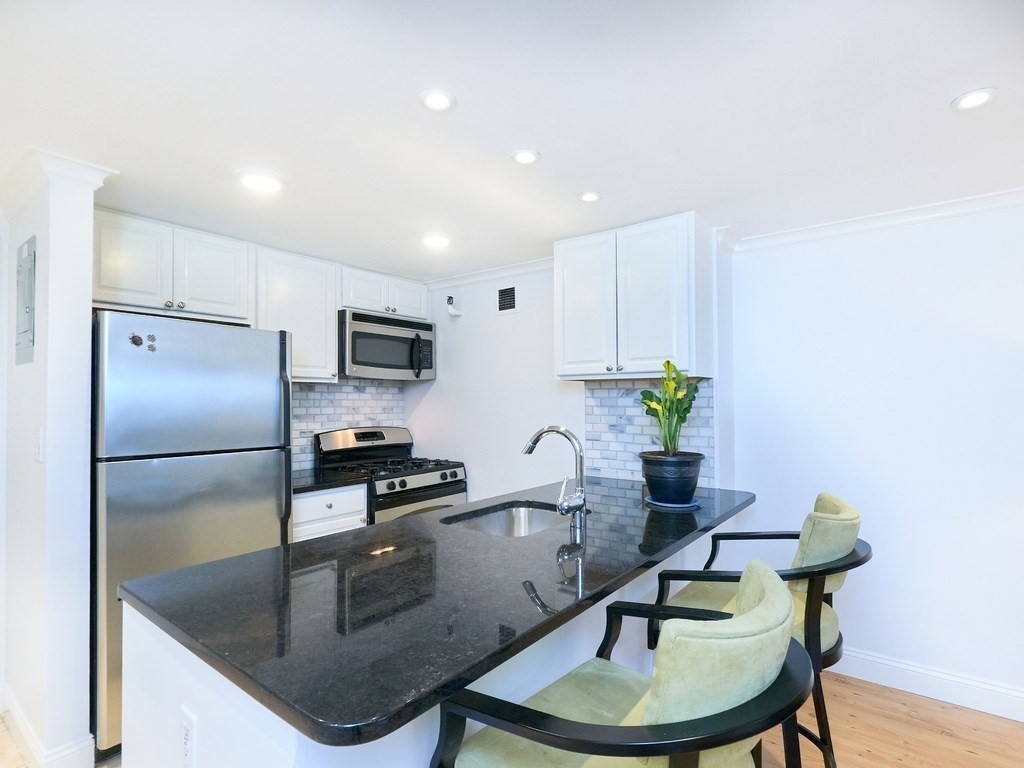 42 8th Street, Unit 5521 Boston, MA 02129 - Photo 8 of 25 a kitchen with stainless steel appliances granite countertop a sink a refrigerator and a granite counter tops