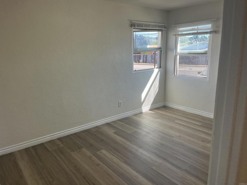 1280 Manor Drive El Cajon, CA 92021 - Photo 11 of 11 an empty room with wooden floor and windows