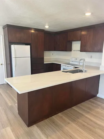 a kitchen with a sink a cabinets and wooden floor