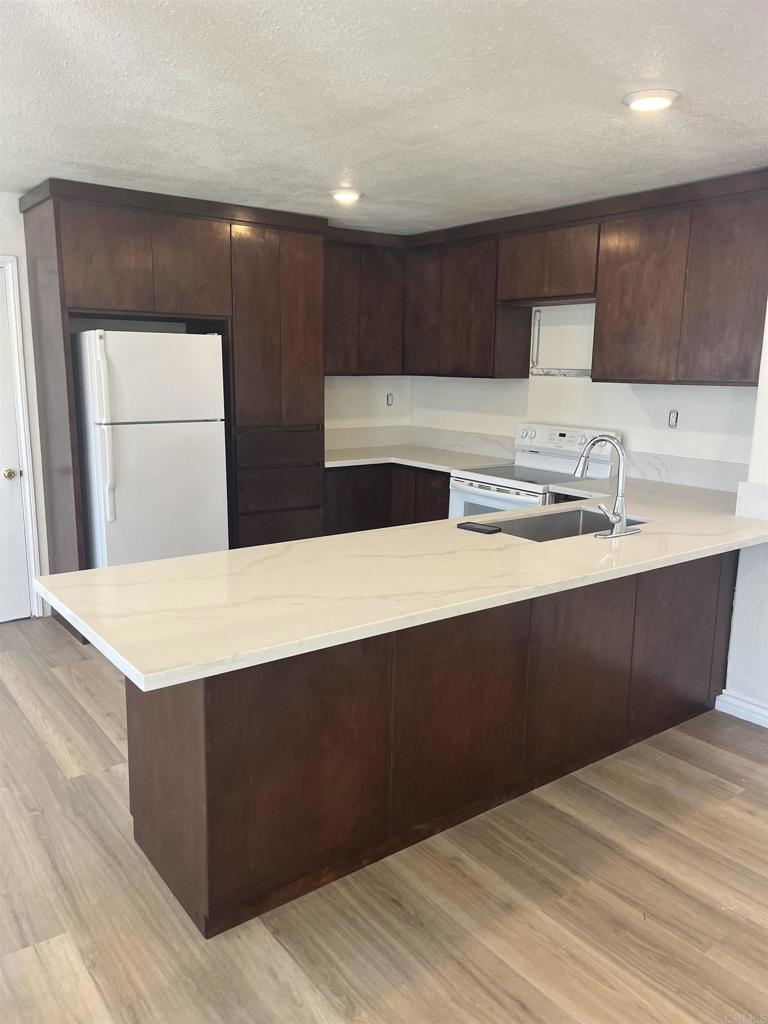 1280 Manor Drive El Cajon, CA 92021 - Photo 3 of 11 a kitchen with a sink a cabinets and wooden floor