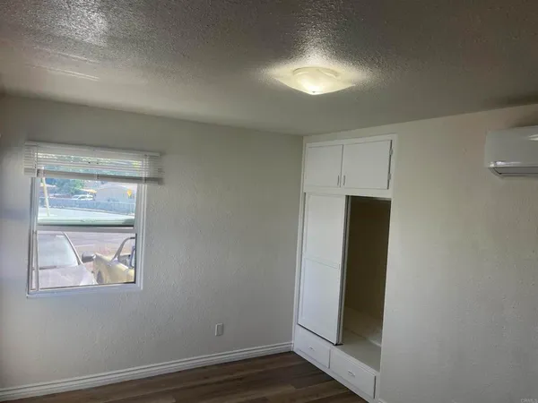 an empty room with wooden floor and closet