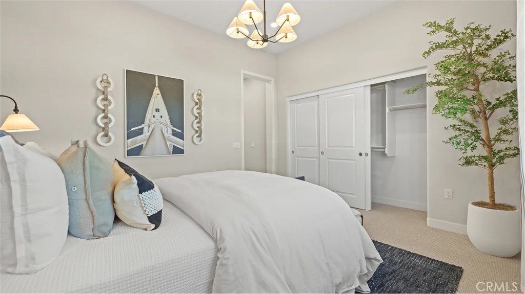 211 Bounty Road Rancho Mission Viejo, CA 92694 - Photo 16 of 28 a spacious bedroom with a bed and a chandelier