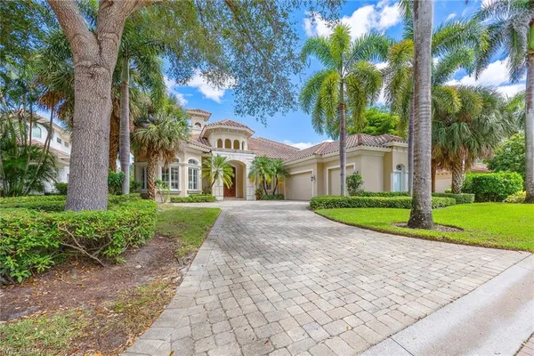 a view of a house with a yard and large trees