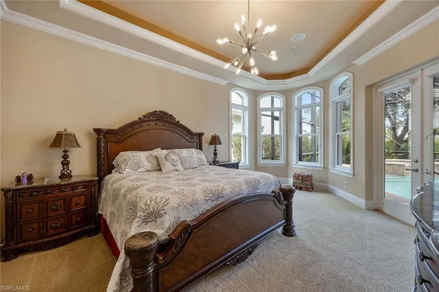 a spacious bedroom with a bed and a chandelier