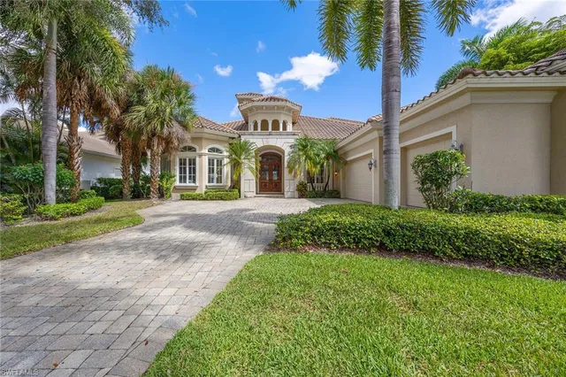 a front view of a house with garden and trees