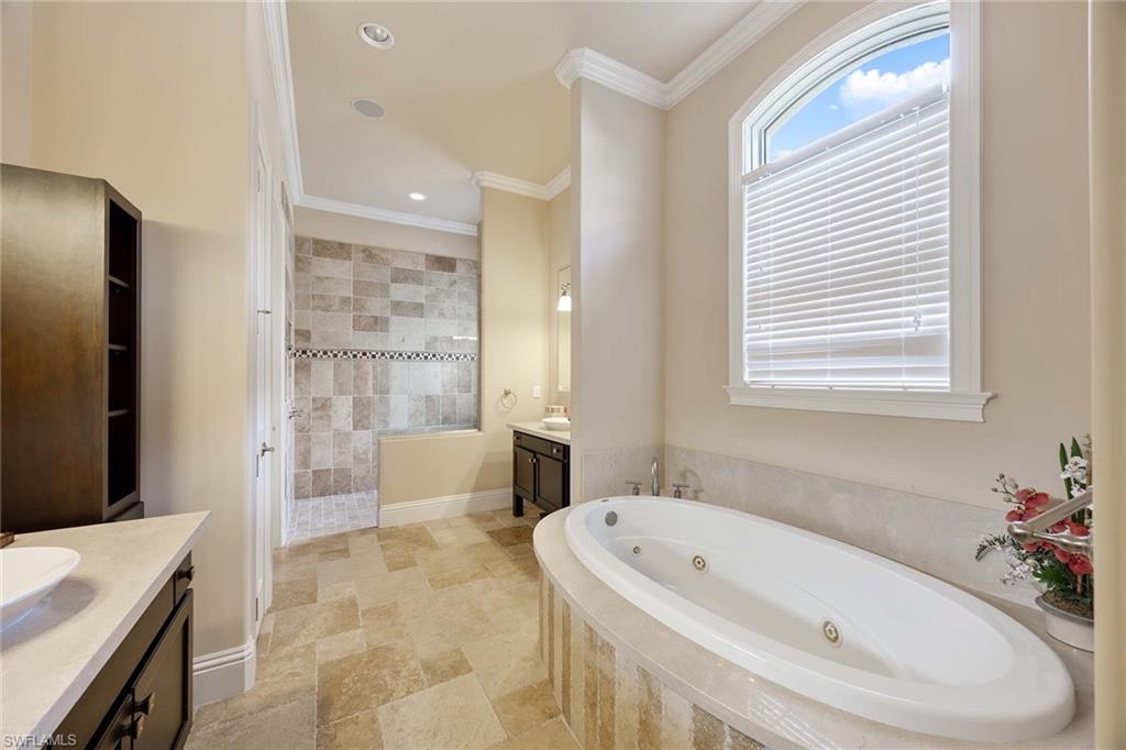 23801 Napoli Way Estero, FL 34134 - Photo 22 of 50 a bathroom with a tub a sink a window and a shower