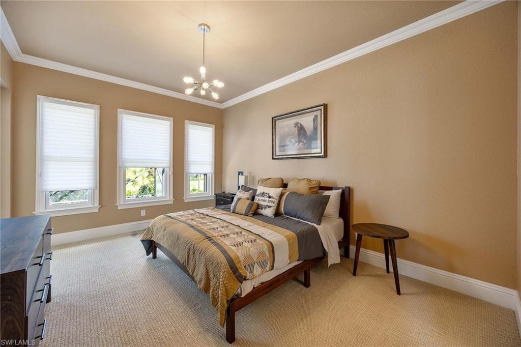 23801 Napoli Way Estero, FL 34134 - Photo 34 of 50 a bedroom with a bed and a chandelier