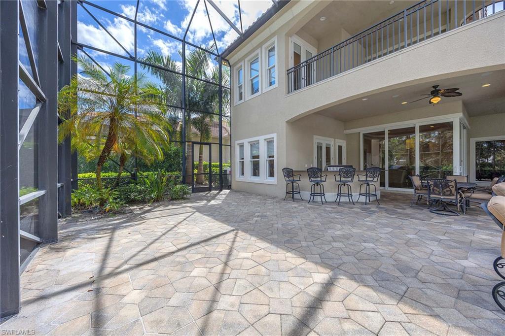 23801 Napoli Way Estero, FL 34134 - Photo 44 of 50 a view of a patio with couches and table and chairs under an umbrella