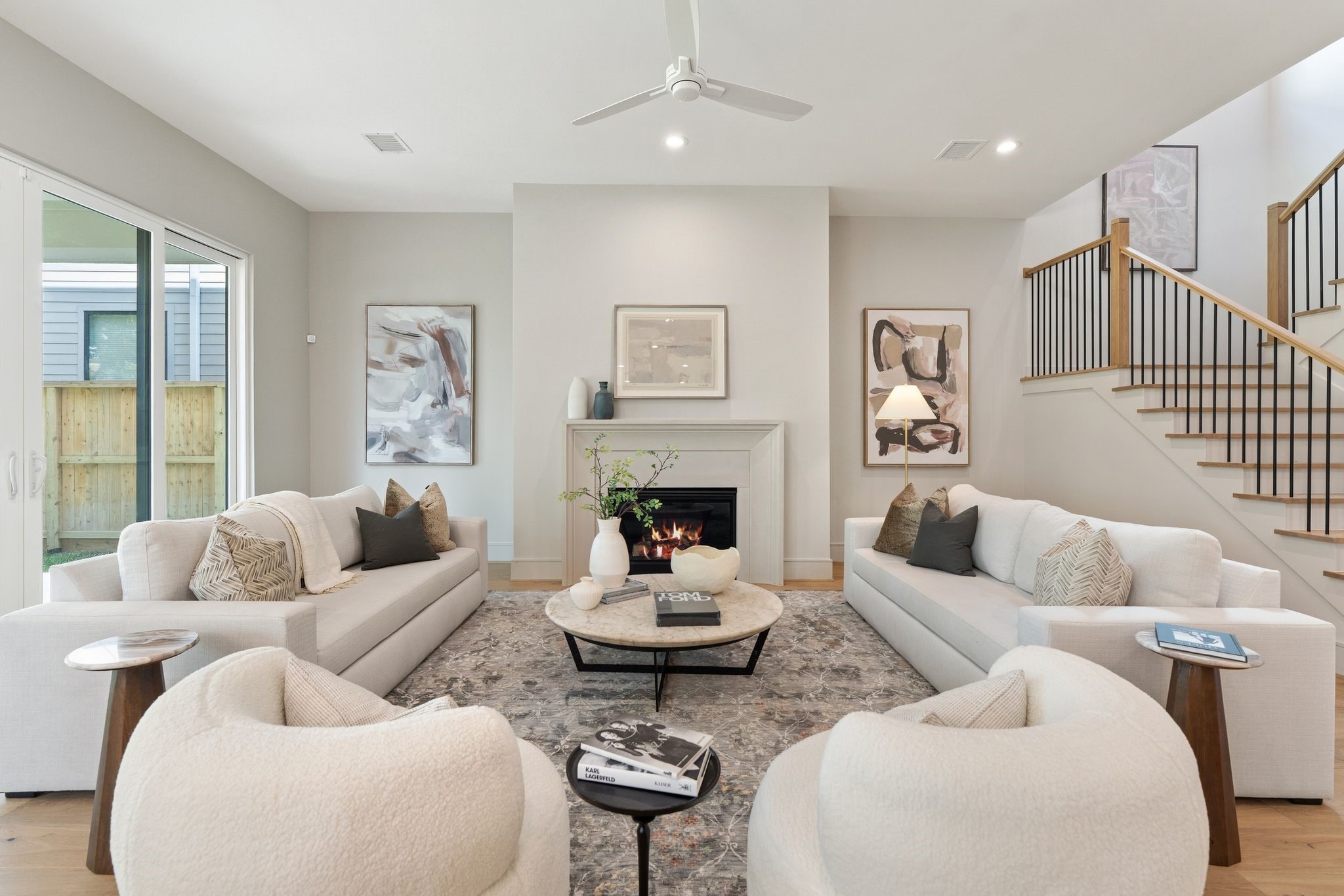 711 East 12th Street Houston, TX 77008 - Photo 11 of 47 A cast stone fireplace anchors the space, while warm hardwood floors connect the open living areas. Expansive windows and sliding glass doors bring the backyard into view and open to the generous covered porch.