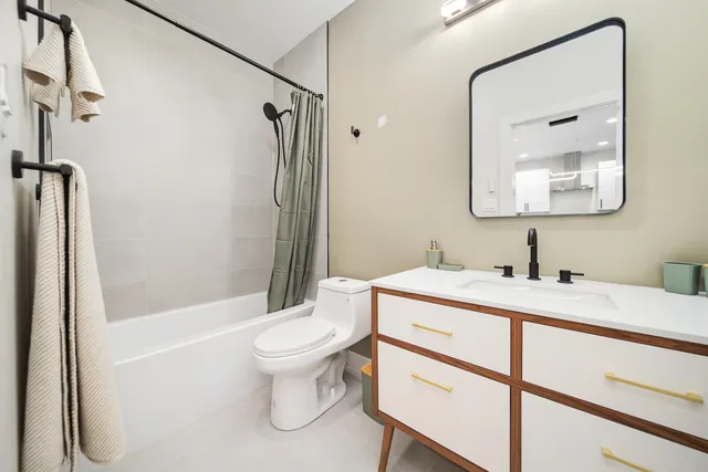 a bathroom with a granite countertop sink toilet and shower