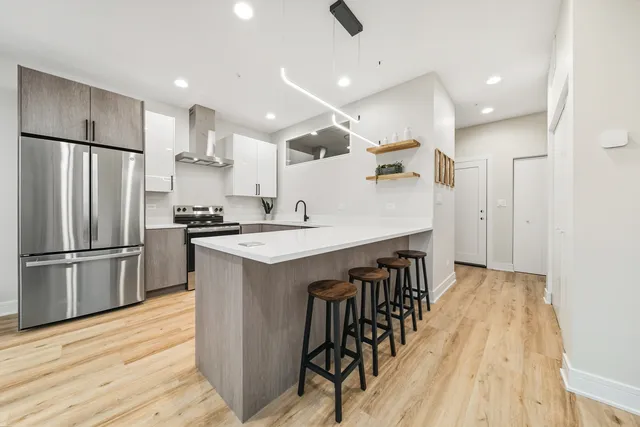 a kitchen with kitchen island white cabinets and stainless steel appliances