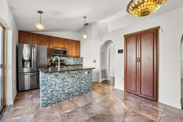 a kitchen with stainless steel appliances granite countertop a refrigerator and a stove