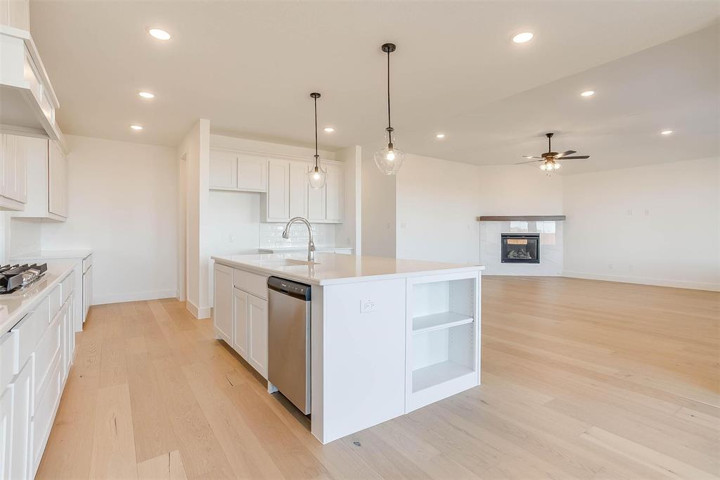826 Feathergrass Place Haslet, TX 76052 - Photo 12 of 35 a kitchen with a stove a sink a refrigerator and a fireplace