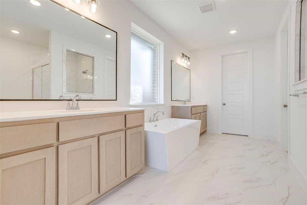 826 Feathergrass Place Haslet, TX 76052 - Photo 19 of 35 a bathroom with a bathtub a sink and a mirror