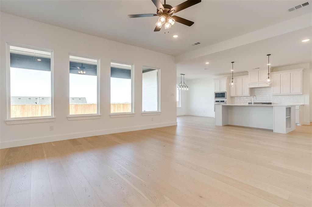 826 Feathergrass Place Haslet, TX 76052 - Photo 5 of 35 a view of an empty room with a window and wooden floor