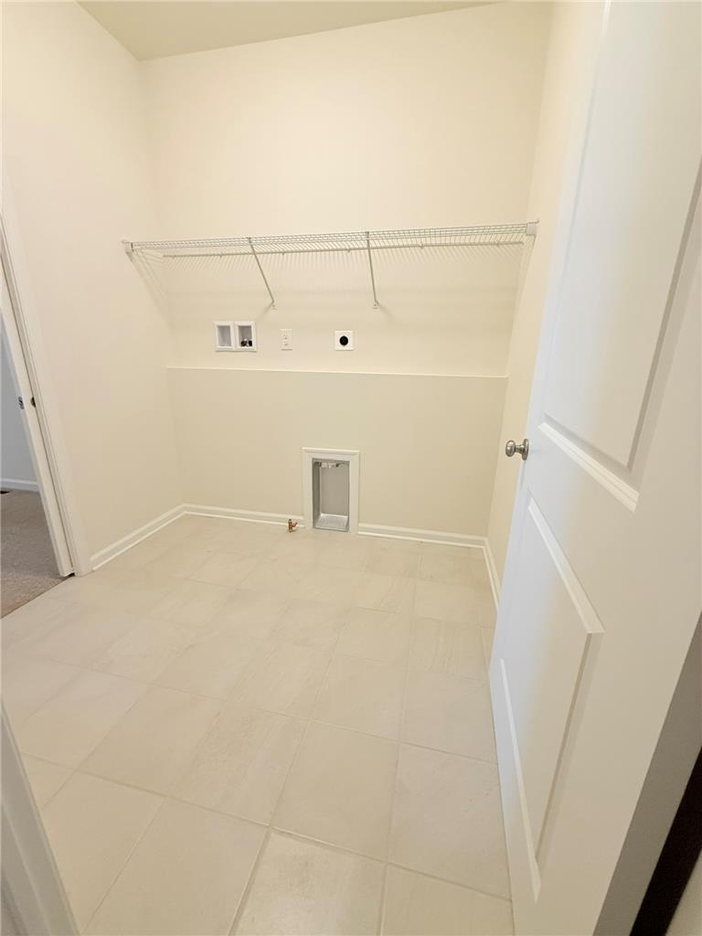 328 Abby Road, Unit LOT 15 Macungie, PA 18062 - Photo 24 of 26 A dedicated laundry space offers practical utility connections and overhead storage shelving.