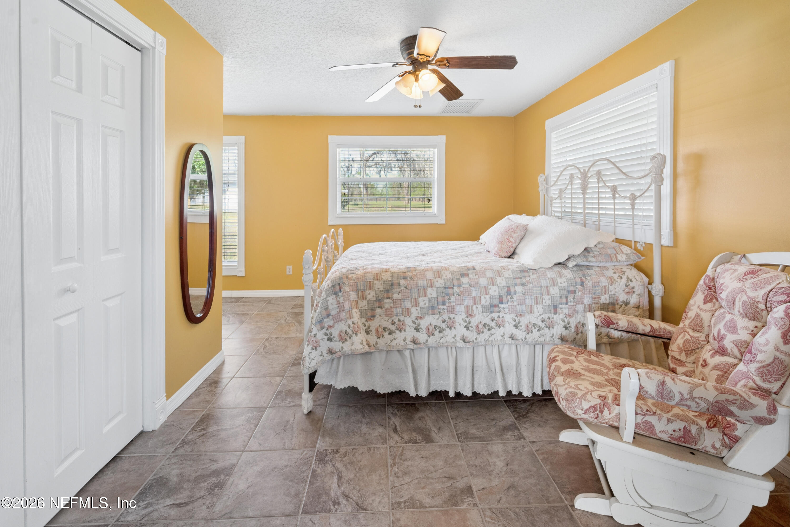 7932 Southwest County Road 18 Hampton, FL 32044 - Photo 12 of 39 a bedroom with a bed and a painting on the wall