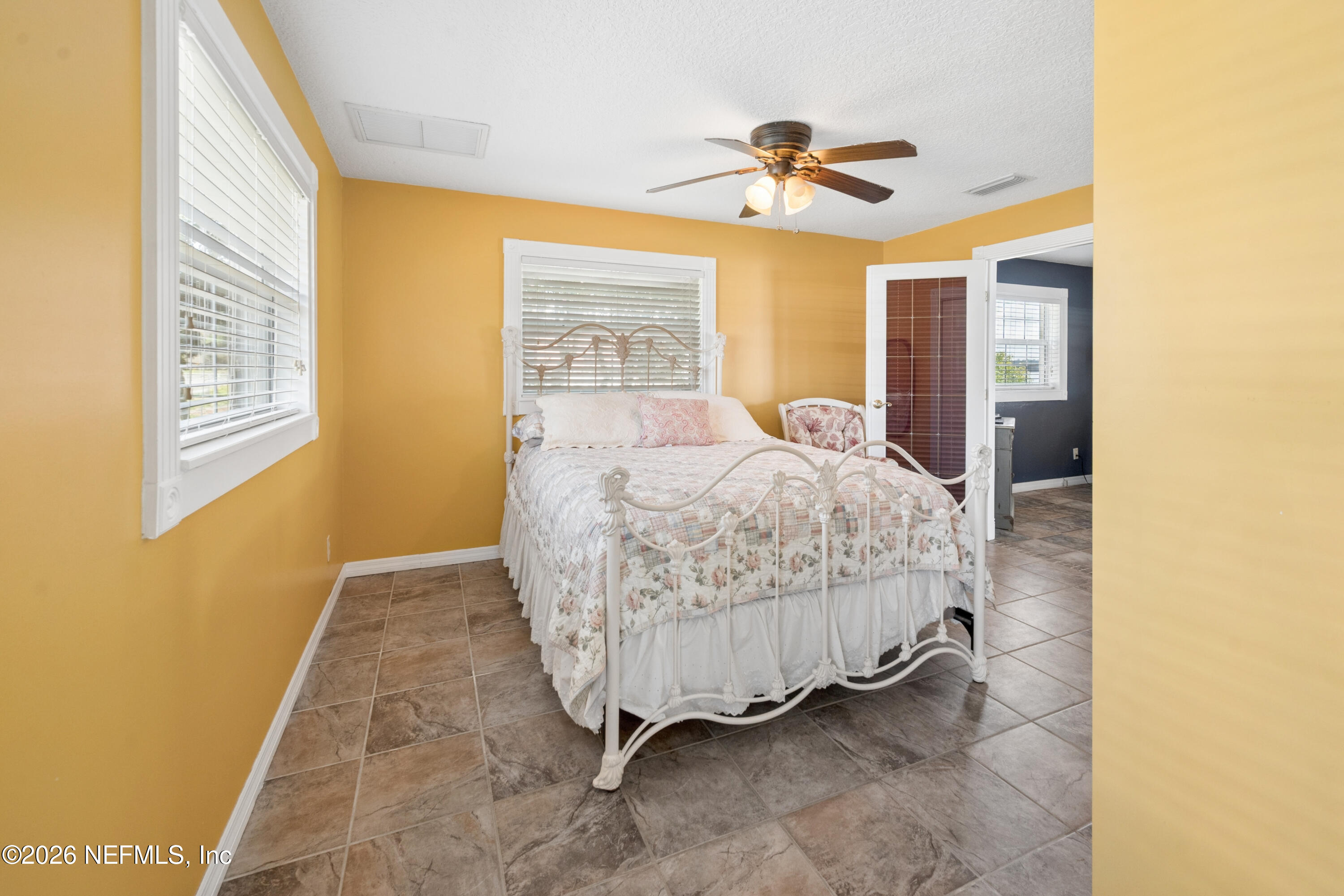 7932 Southwest County Road 18 Hampton, FL 32044 - Photo 13 of 39 a bedroom with a bed and a chandelier