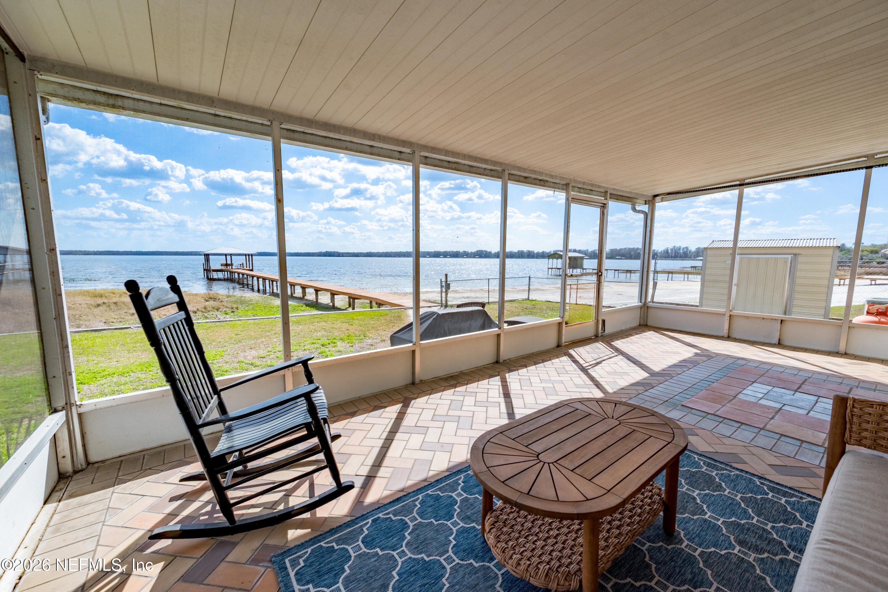 7932 Southwest County Road 18 Hampton, FL 32044 - Photo 28 of 39 a living room with furniture a rug and a floor to ceiling window