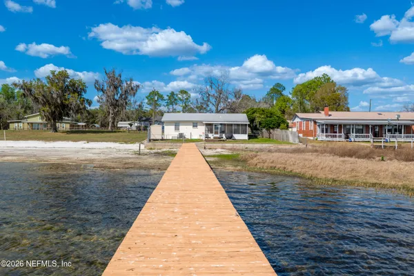 a view of a balcony with chairs and wooden floor