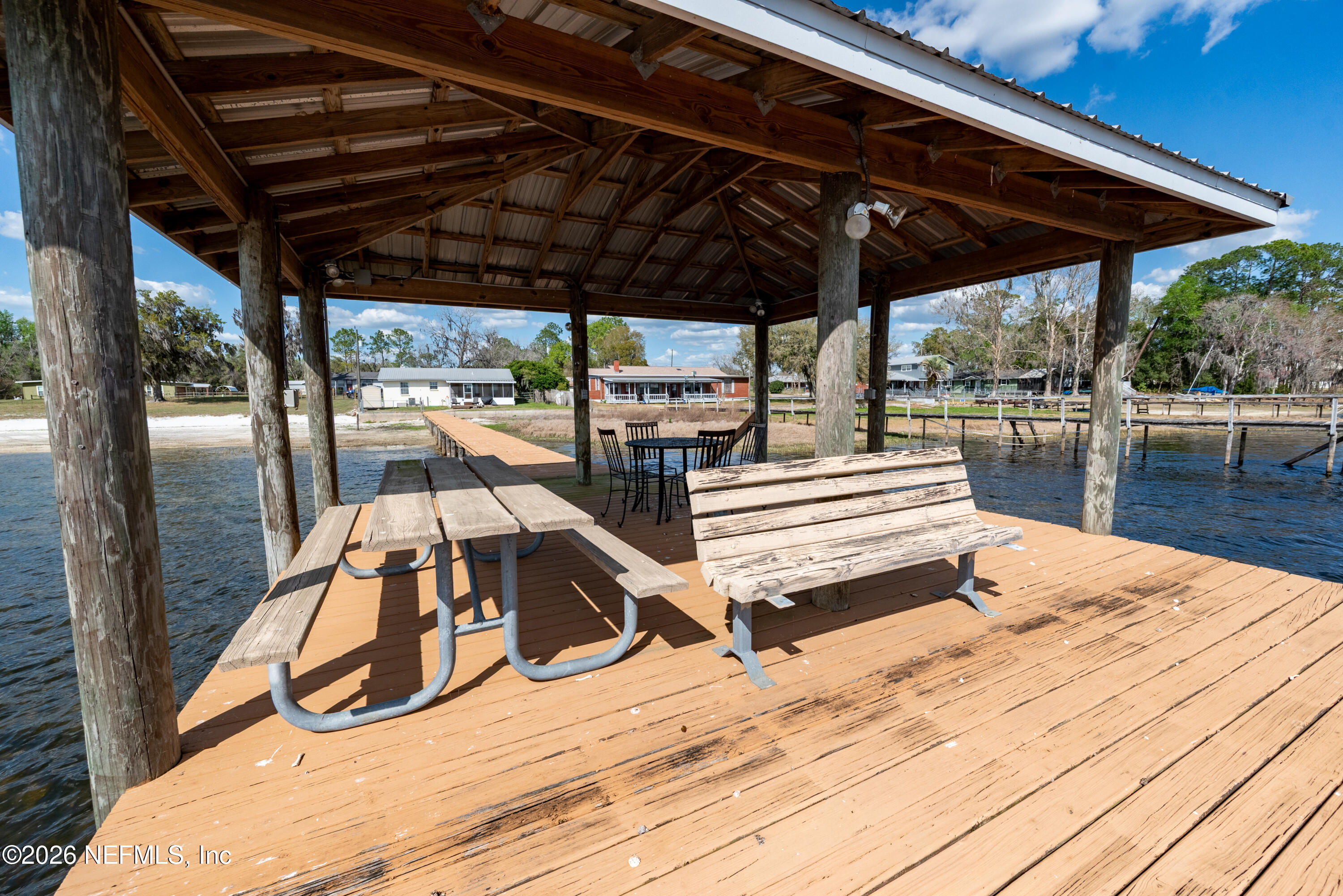7932 Southwest County Road 18 Hampton, FL 32044 - Photo 33 of 39 a view of a patio with a table and chairs under an umbrella with a wooden floor